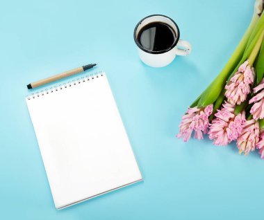 Morning cup of coffee and pink spring flowers on blue background. Breakfast for Birthday, Holiday, Women day, Mother day, Valentine's Day concept
