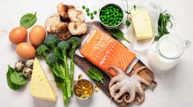 Beyaz arkaplanda D vitamini bakımından zengin ürünlerin bileşimi, üst görünüm.