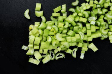 Raw celery on dark background. Healthy food. Top view, flat lay, copy space
