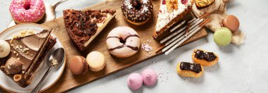 Ahşap bir masa üzerinde çeşitli pasta parçaları, kurabiyeler, kurabiyeler ve çörekler. Üst Manzara. Şekerleme arkaplanı.