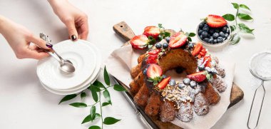 Bundt Cake with strawberry and berry on a light  background. Festive cake. Top view. Panorama.