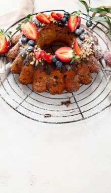 Bundt Cake with strawberry and berry on a light  background. Festive cake. Top view.