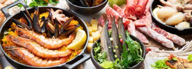 Assortment various Mediterranean food - fish, octopus, shrimp,  seafood, mussels, sauces, pasta, pizza on a white background. Top view. Panorama, banner.
