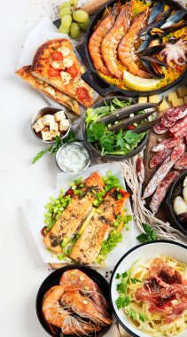 Assortment various Mediterranean food - fish, octopus, shrimp,  seafood, mussels, sauces, pasta, pizza on a white background. Top view.