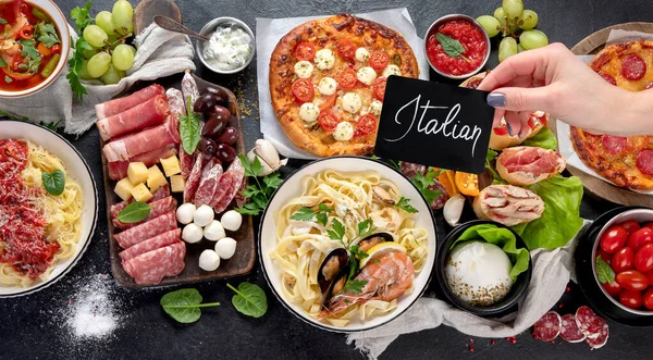 Italian food dishes on dark background. Traditional italian cuisine  concept. Dishes and appetizers of indeed cuisine. Mideterranean diet food high in vitamin and antioxidants. Top view, copy space