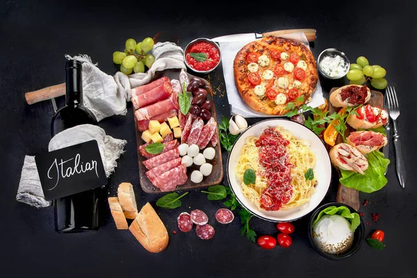 Italian food dishes on dark background. Traditional italian cuisine  concept. Dishes and appetizers of indeed cuisine. Mideterranean diet food high in vitamin and antioxidants. Top view