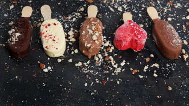 Popsicle ice-cream assortment on dark background. Spring natural background. 