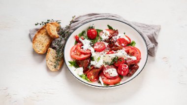 Domates, fesleğen, mozzarella. Zeytinyağlı Caprese salatası. Üst görünüm, beyaz arkaplan.