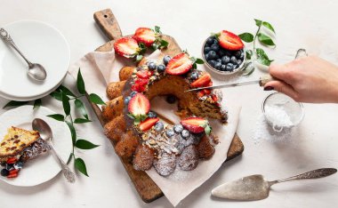 Bundt Cake with strawberry and berry on a light  background. Festive cake. Top view.