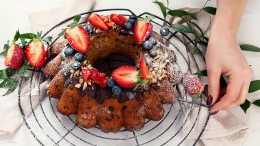 Bundt Cake with strawberry and berry on a light  background. Festive cake. Top view. Panorama.