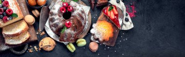 Koyu arkaplanda farklı tatlılar. Pastalı, çikolatalı ve kırmızı kadife kekli lezzetli tatlı masası. Tatil tatlısı yeme konsepti. Üst görünüm, kopyalama alanı, panorama, pankart