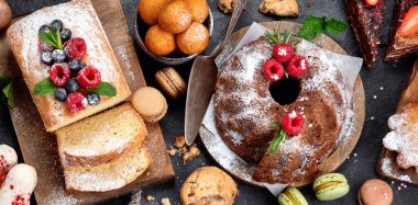 Koyu arkaplanda farklı tatlılar. Pastalı, çikolatalı ve kırmızı kadife kekli lezzetli tatlı masası. Tatil tatlısı yeme konsepti. Üst görünüm