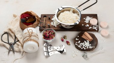 Ev yapımı doğal beyaz eko soya mumları cam, fitil, parfüm. Hobi için fikir, iş için. Beyaz arka planda sağlığa zarar vermeden modaya uygun mumlar yapmak. Üst görünüm.