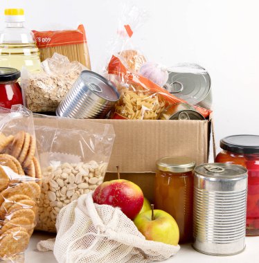 Gıda bağış kutusu, arka planda farklı ürünler, üst manzara. Yiyecek bağışları ya da teslimat konsepti.