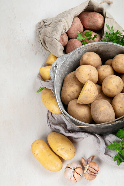Raw potato food. Fresh potatoes in an old cooking pot on a white background. Top view. Copy space.
