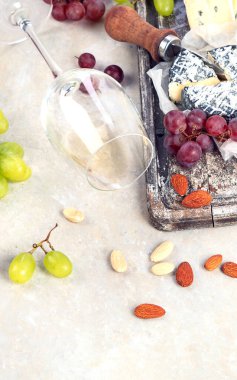 Pink and red wine served with cheeses, nuts, grapes and glasses of wine. Delicious food wine snacks assorted served on boards. Flat lay on a white  background. Panorama.