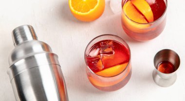 Masada farklı lezzetli kokteyller var. Beyaz arka planda meyve, bitki ve buzlu alkolik kuyruk. Üst görünüm.