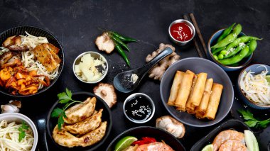 Siyah arka planda çeşitli Asya yemekleri, üst manzara. Asya yemekleri konsepti. Boşluğu kopyala