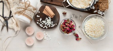 Ev yapımı doğal beyaz eko soya mumları cam, fitil, parfüm. Hobi için fikir, iş için. Beyaz arka planda sağlığa zarar vermeden modaya uygun mumlar yapmak. Üst görünüm.