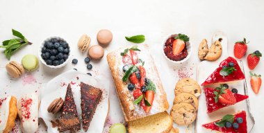 Hafif arka planda her türlü abur cubur olan tatlı masası. Çikolata. Kutlama konsepti. Üst manzara, düz yatış. Kopyalama alanı olan Panorama.