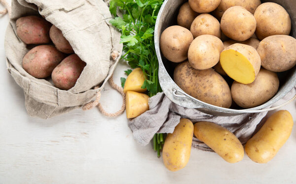 Raw potato food. Fresh potatoes in an old cooking pot on a white background. Top view