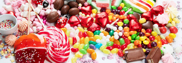Assortment of colorful candy on a white background. Top view. panorama.