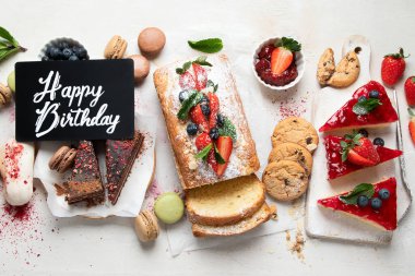 Hafif arka planda her türlü abur cubur olan tatlı masası. Çikolata. Kutlama konsepti. Üst manzara, düz uzanma.