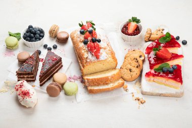 Hafif arka planda her türlü abur cubur olan tatlı masası. Çikolata. Kutlama konsepti. Üst manzara, düz uzanma.