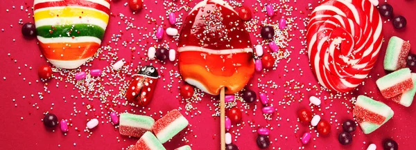 분홍색 배경에 색상의 사탕들이 있습니다 위에서 파노라마 현수막 — 스톡 사진