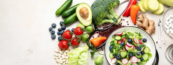 Top view of healthy food in plate with stethoscope, cholesterol diet and diabetes control on white background. World health day and medical concept. Panorama with copy space.