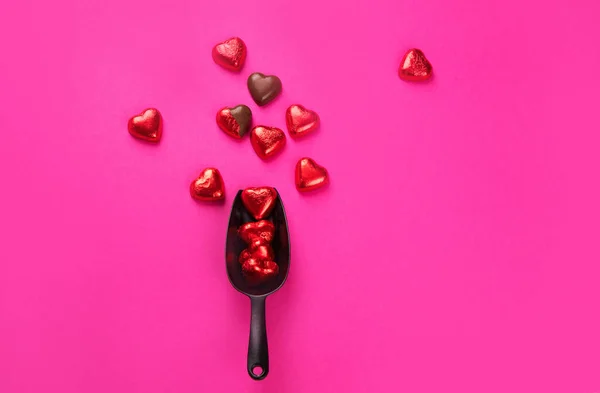 用粉色背景红箔包裹并打开包装的心形巧克力糖果 爱情的概念 高瞻远瞩 — 图库照片