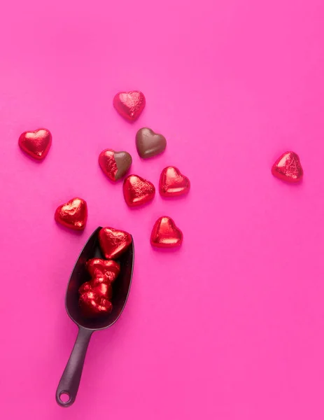 Caramelle Cioccolato Forma Cuore Avvolte Scartate Lamina Rossa Sfondo Rosa — Foto Stock