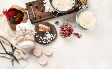 Ev yapımı doğal beyaz eko soya mumları cam, fitil, parfüm. Hobi için fikir, iş için. Beyaz arka planda sağlığa zarar vermeden modaya uygun mumlar yapmak. Üst görünüm.