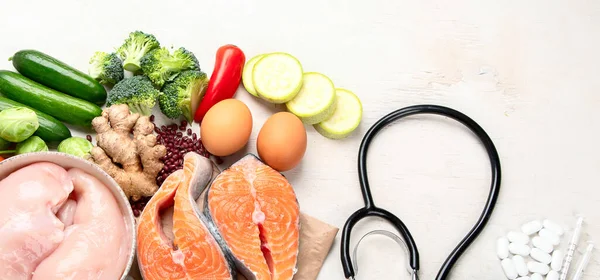 Top view of healthy food in plate with stethoscope, cholesterol diet and diabetes control on white background. World health day and medical concept. Panorama with copy space.