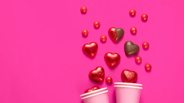Eingewickelte Und Ausgepackte Herzförmige Schokoladenbonbons Roter Folie Auf Rosa Hintergrund — Stockfoto
