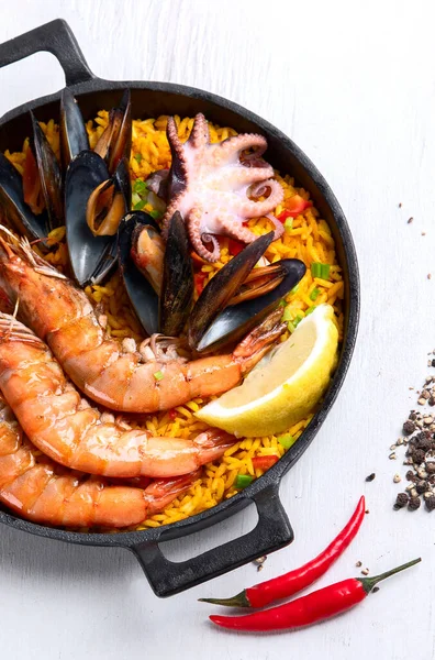 经典的西班牙菜 海鲜海鲜饭放在传统的平底锅上 顶部观景 西班牙海鲜 上面有虾仁 青豆和新鲜柠檬片 复制空间 — 图库照片