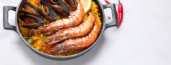 经典的西班牙菜 海鲜海鲜饭放在传统的平底锅上 顶部观景 西班牙海鲜 上面有虾仁 青豆和新鲜柠檬片 具有复制空间的全景 — 图库照片