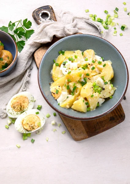 色拉土豆 绿色洋葱和蛋黄酱在一个白色背景的盘子上 顶部视图 复制空间 — 图库照片