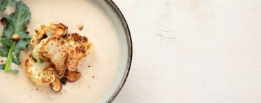 Arka planda fındıklı ve otlu kremalı karnabahar çorbası. Üst Manzara. Kopyalama alanı olan Panorama.