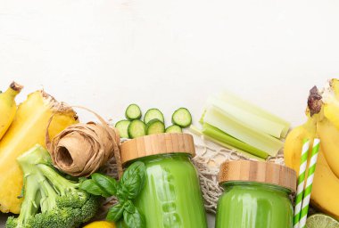 Beyaz arka planda, çevre dostu bir kavanozda, sağlıklı yeşil bir smoothie. Sıfır atık ve sağlıklı diyet konsepti