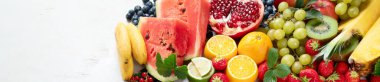 Taze meyveler, beyaz bir zemin üzerinde çeşitli meyveler. Vitaminler doğal beslenme konsepti. Panorama, kopyalama alanı olan pankart.