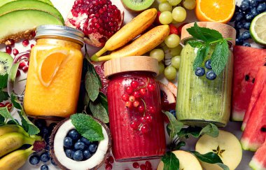 Taze meyve ve sebze suyu ya da çeşitli içerikli hafif arka plan içerikli meyve suyu. Üst görünüm, alanı kopyala