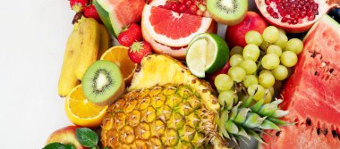 Taze meyveler, beyaz bir zemin üzerinde çeşitli meyveler. Vitaminler doğal beslenme konsepti. Panorama.