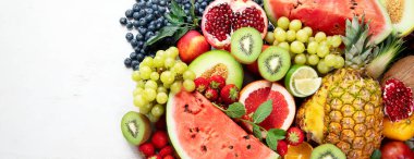 Taze meyveler, beyaz bir zemin üzerinde çeşitli meyveler. Vitaminler doğal beslenme konsepti. Kopyalama alanı olan Panorama.