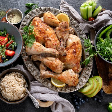 Pilavlı tavuk bacağı, sebze salatası ve koyu arkaplanda sos. Sağlıklı yemek konsepti. Üst görünüm.