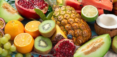 Mavi arka planda çeşitli taze meyveler. Vitaminler doğal beslenme konsepti. Üst görünüm.