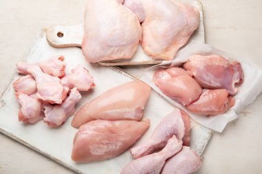 Çiğ tavuk filetosu, but, kanatlar ve bacaklar beyaz arka planda. Üst görünüm.