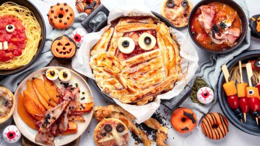 Gri arka planda eğlenceli bir Cadılar Bayramı parti masası sahnesi. Üst Manzara. Pizza, pasta, spagetti ve aperatif.