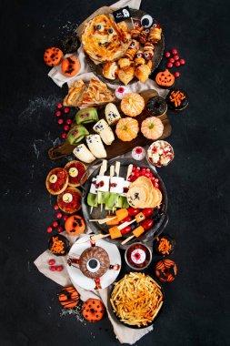 Gri arka planda eğlenceli bir Cadılar Bayramı parti masası sahnesi. Üst Manzara. Pizza, pasta, spagetti ve aperatif..