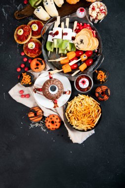 Gri arka planda eğlenceli bir Cadılar Bayramı parti masası sahnesi. Üst Manzara. Pizza, pasta, spagetti ve atıştırmalıklar. Boşluğu kopyala.